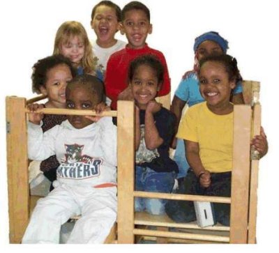 Eight children playing on a gym set in a classroom