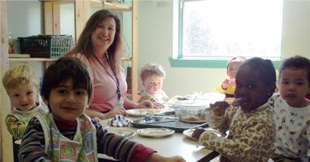 Children in a classroom at a table eating.